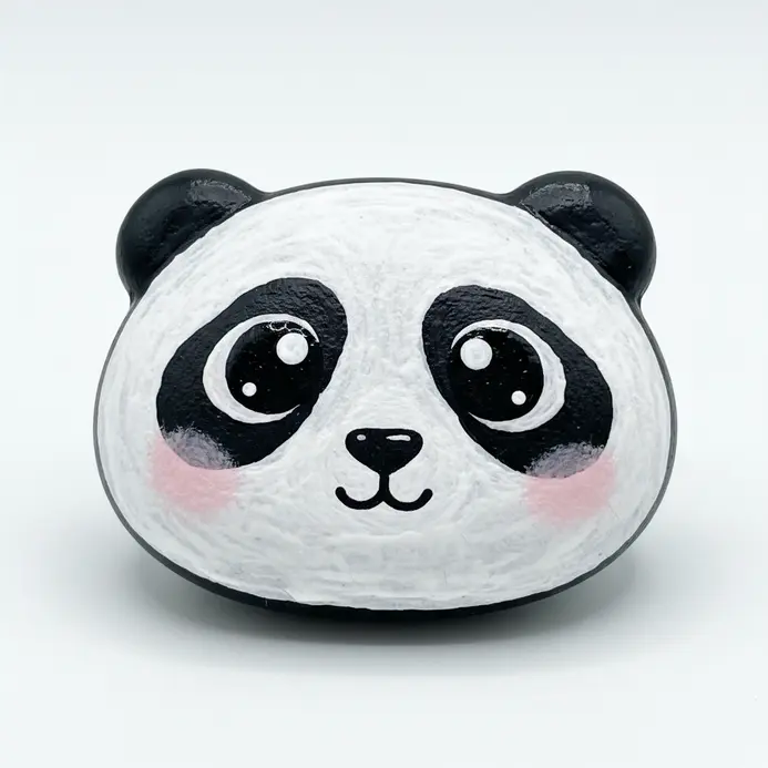 A round rock painted as a kawaii panda face in black and white