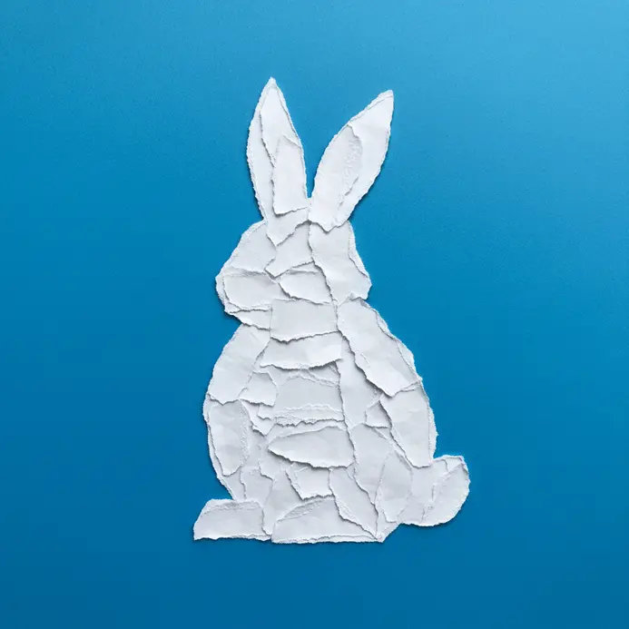 Torn paper collage of an Easter bunny on a blue background.