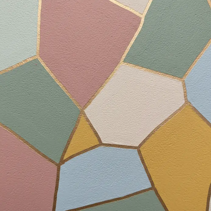 A light gray wall with decorative magnets holding artwork.