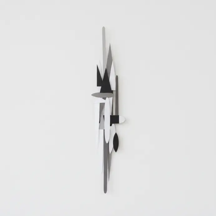 Tall slender column of abstract paper shapes on a narrow wall