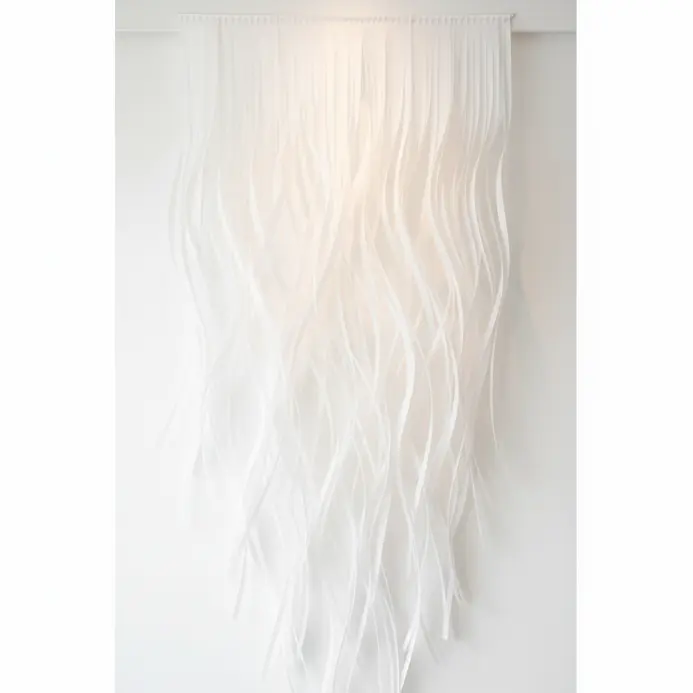 Very tall flowing paper sculpture installed on a high ceiling wall