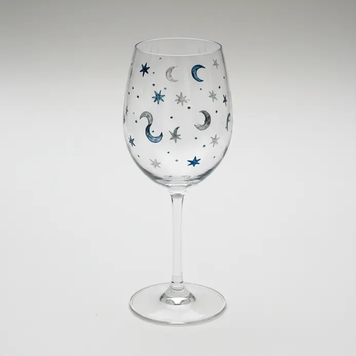 A pencil sketch of a wine glass with small moons and stars scattered across the bowl in loose spacing.
