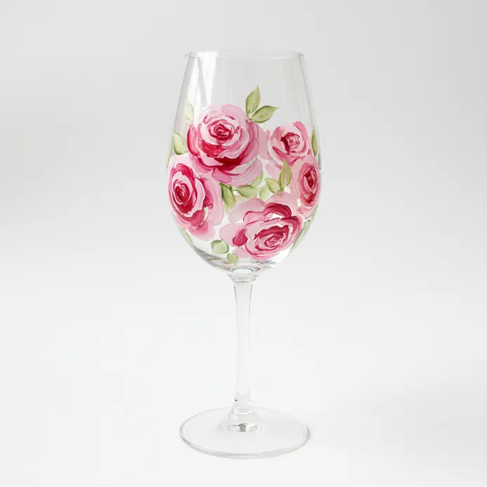 A wine glass drawing showing a cluster of roses across the lower bowl with loose petal outlines and light spacing.