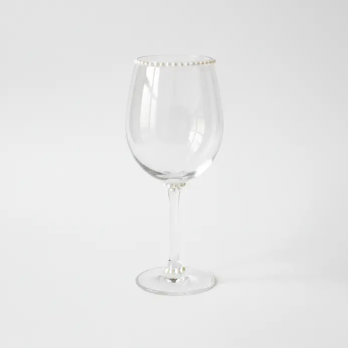 A wine glass sketch with tiny pearl-like dots tracing the bowl edge and a few small accents near the base.