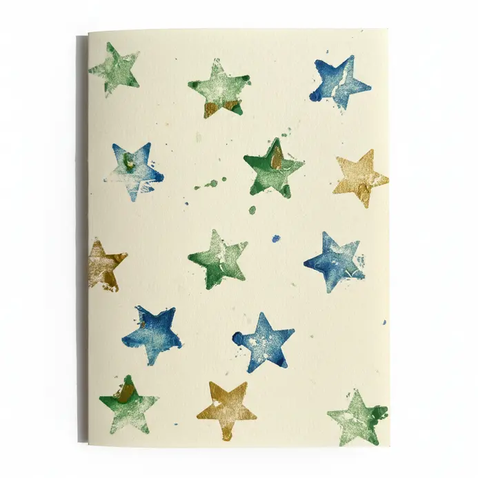 A folded paper card showing repeating star shapes made from potato stamping with red paint.