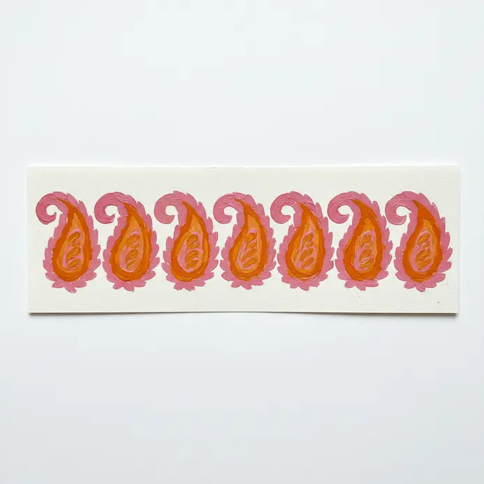 Straight row of identical painted paisley motifs in alternating bright pink and orange colors.