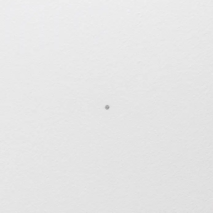 A single tiny pencil dot placed near the center of clean white drawing paper.