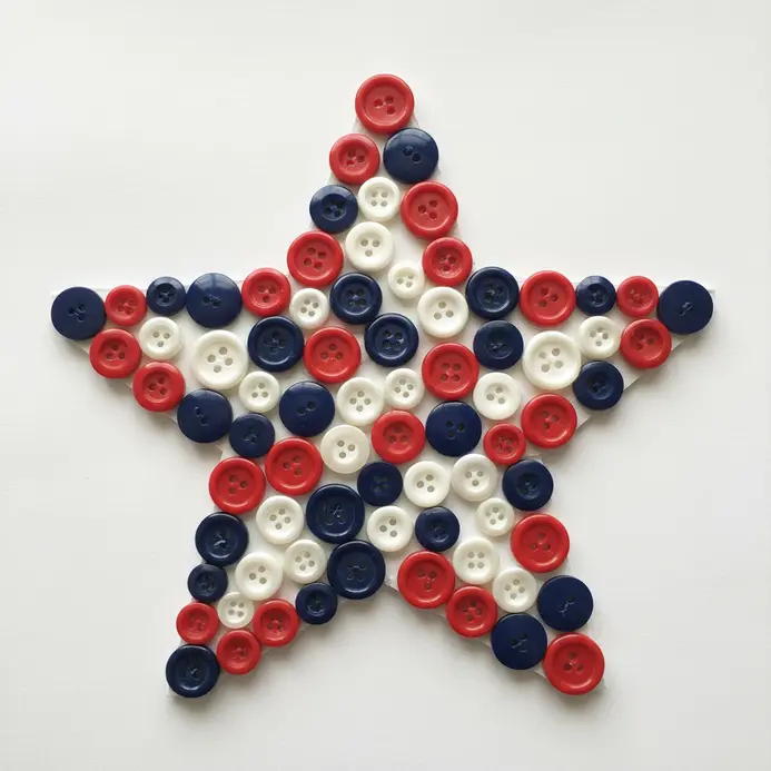 A large star outline on cardboard filled with glued red, white, and blue buttons.