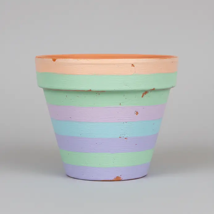 Horizontal stripes in soft pastel rainbow colors wrap around a terracotta pot.