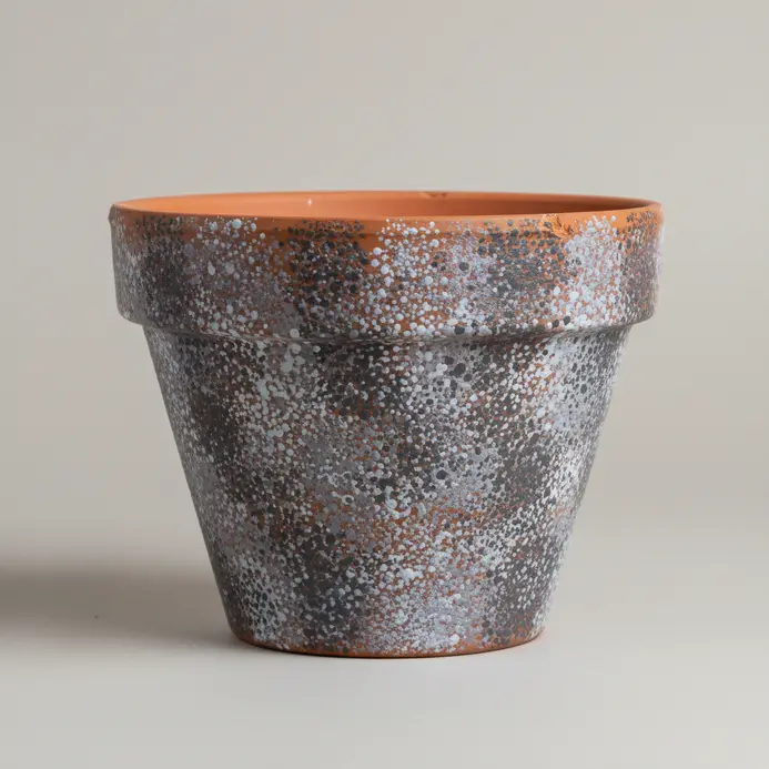 A monochromatic grey texture covers a pot, created using a stippling paint technique.