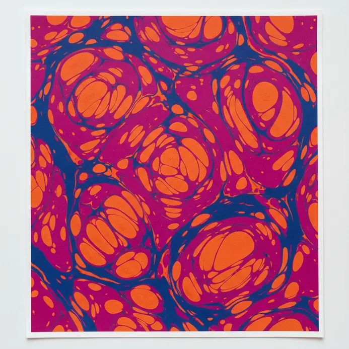 A piece of paper covered in vibrant, swirled patterns created through a simple marbling technique.