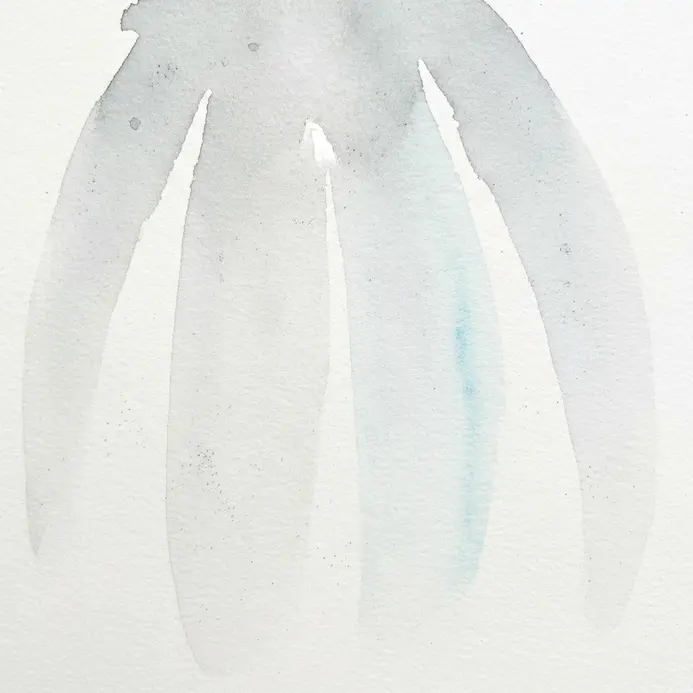 Three clean watercolor brushes with pointed tips resting upright in a jar.