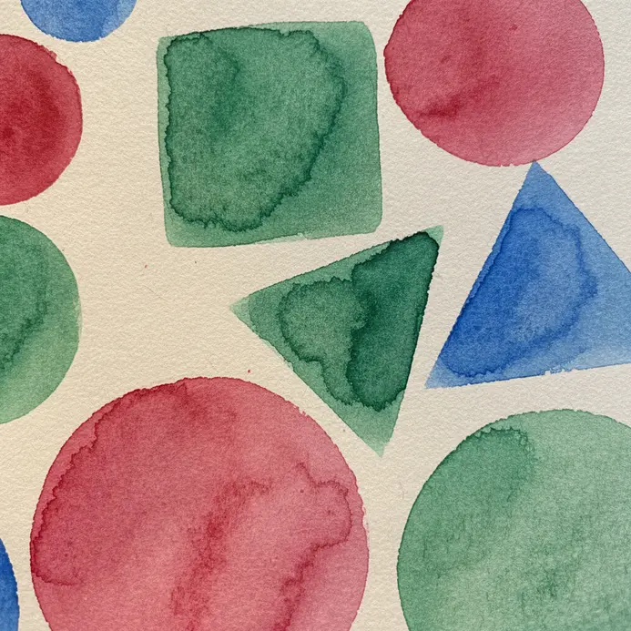A practice sheet with simple watercolor shapes like circles, squares, and triangles in various colors.