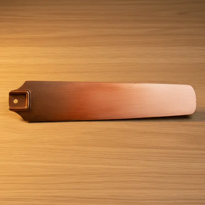 A fan blade showing a smooth ombre blend from dark bronze to bright, shimmering copper metallic paint.