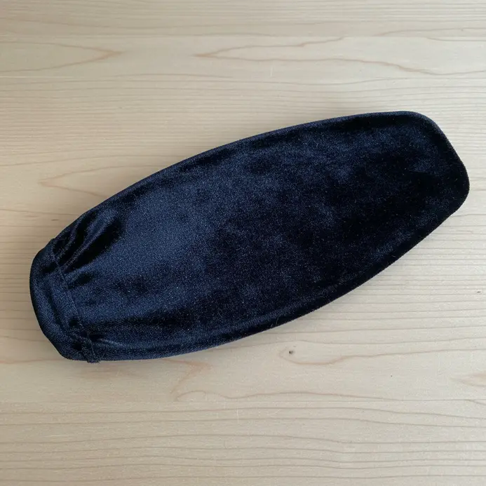 A ceiling fan blade tightly covered in a piece of luxurious black velvet fabric, edges neatly tucked and glued.