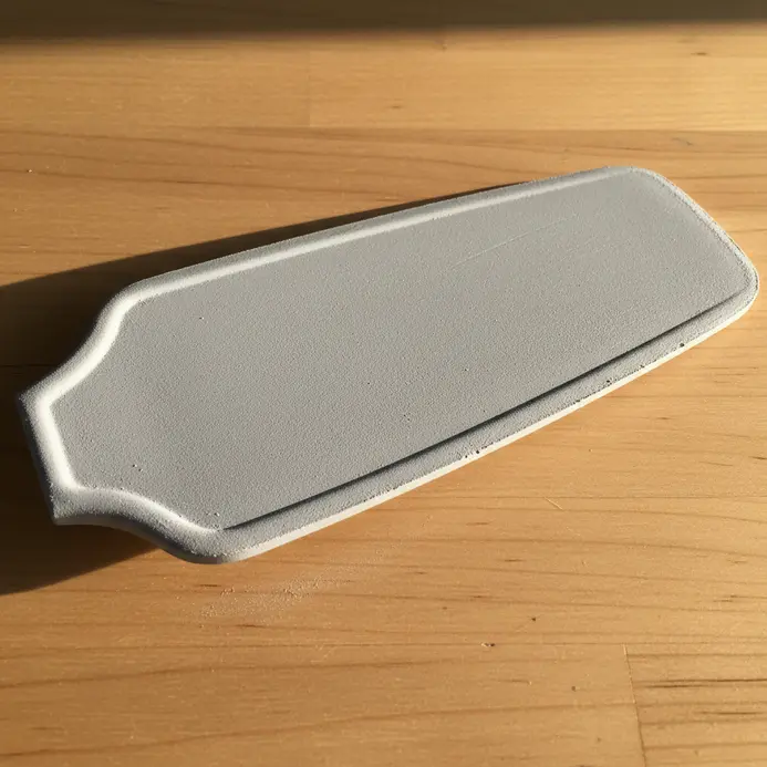 A ceiling fan blade coated in a matte, soft grey chalkboard paint, ready for temporary chalk drawings.
