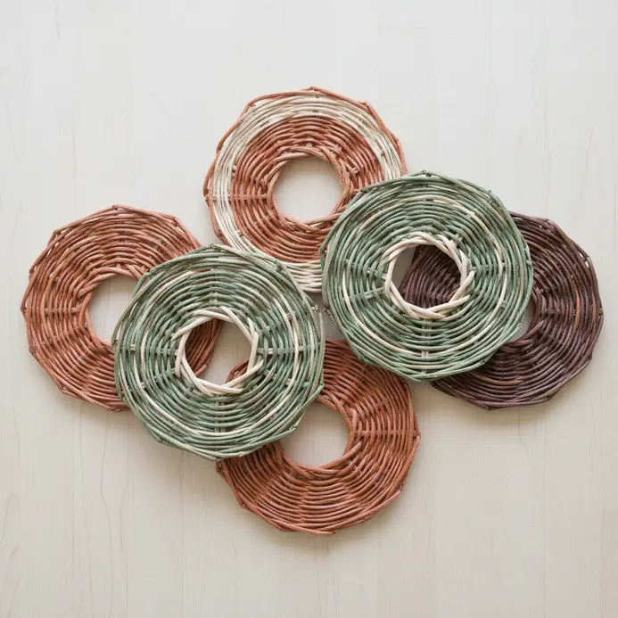 Several square coasters with a woven pattern made from interlocking natural wood popsicle sticks.