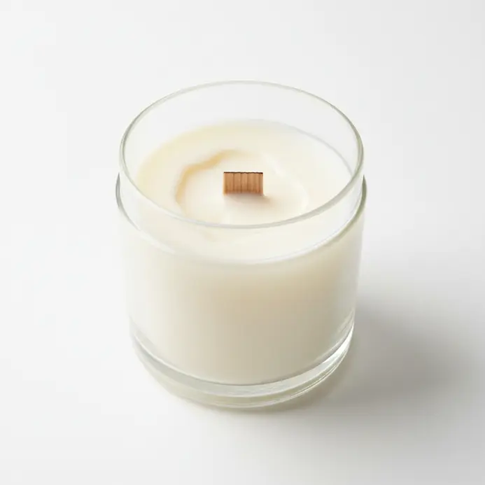 A creamy white soy wax candle in a simple jar, with a wooden wick.