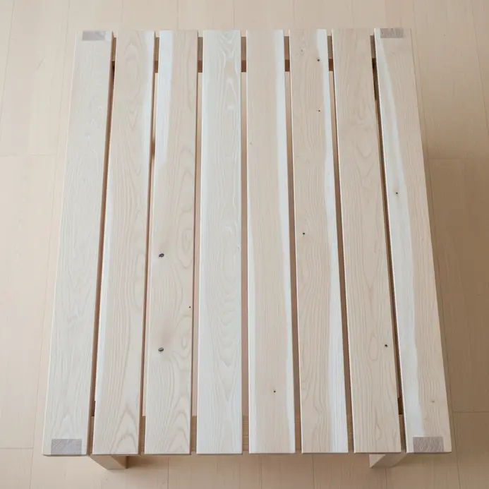 A low, rectangular coffee table made from evenly spaced white oak slats.