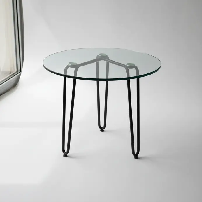 A clear glass rectangle resting on three thin black metal hairpin legs.