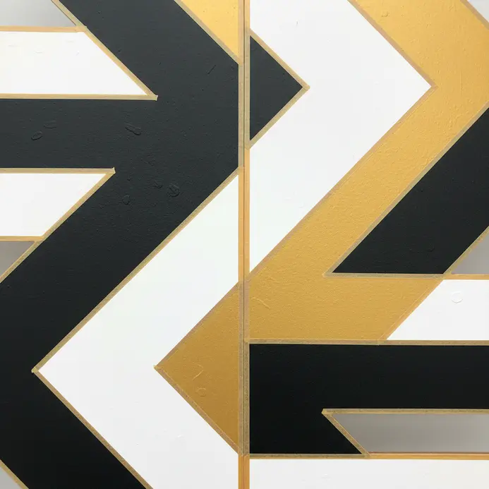 A wooden folding screen with a repeating, high-contrast geometric border along each panel's edge.