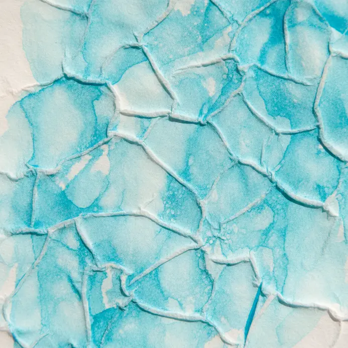A teal watercolor wash pressed with crinkled paper to create a veined, marble-like texture.
