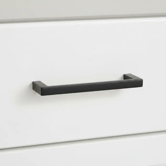 Close-up of sleek matte black cabinet pulls installed on a white painted vanity drawer.
