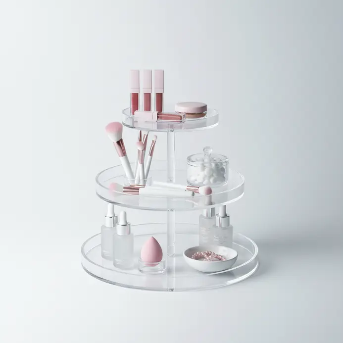 A three-tiered clear acrylic organizer displaying lipsticks, brushes, and skincare products on a vanity.