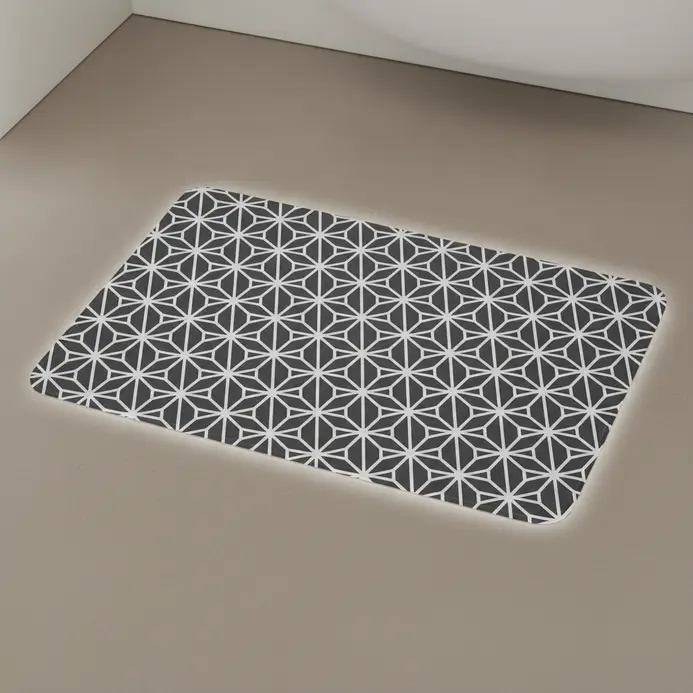 A waterproof vinyl floor mat with a geometric pattern laid down in front of a shower or bathtub.