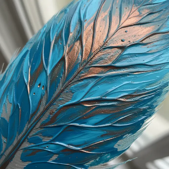 A feather painted with swirling, abstract patterns blending turquoise blue and copper metallic paint.