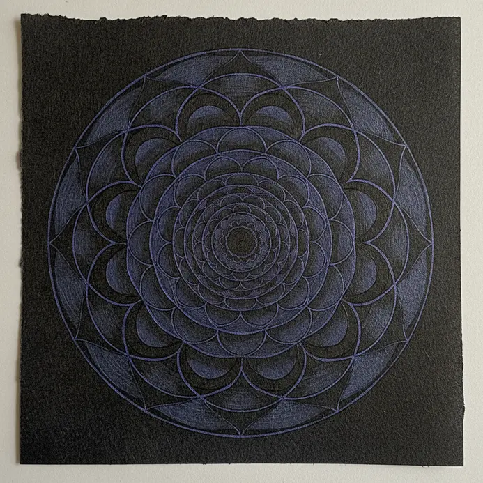 Nested circle mandala drawn with fine black ink pen, featuring repeating arcs and petal shapes.