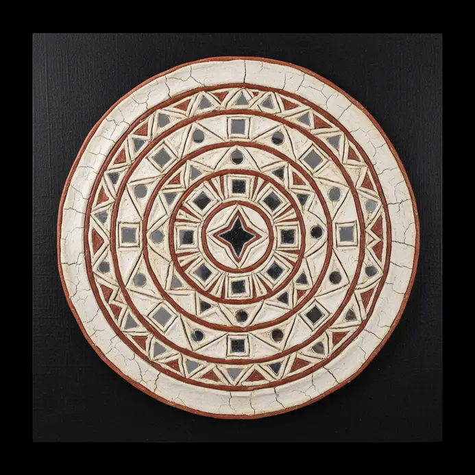 Circular Lippan clay wall art with small mirrors embedded in concentric rings and geometric patterns.