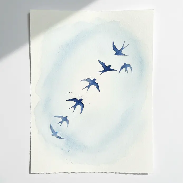 A flock of black swallow silhouettes flying against a soft blue watercolor sky.