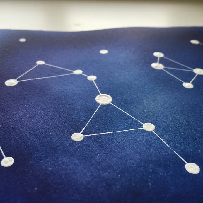 A deep blue watercolor background with white dots connected into constellation patterns.