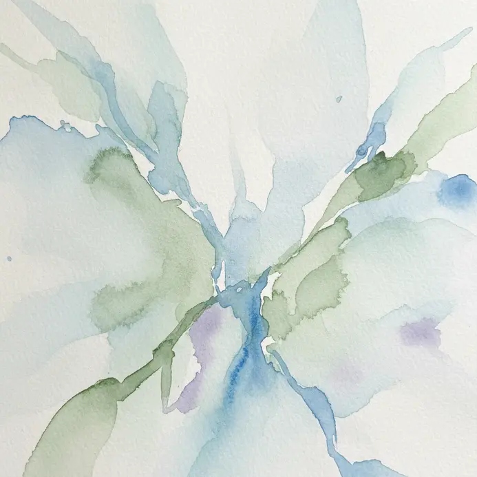 Gentle watercolor pigments bloom on paper in a quiet, sunlit studio space.