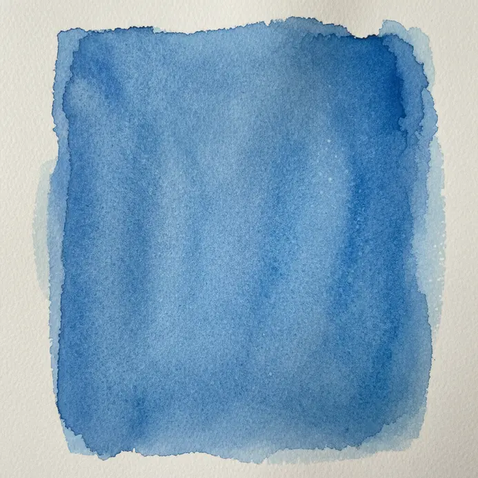 A rectangular section of watercolor paper filled with a uniform, solid blue wash.