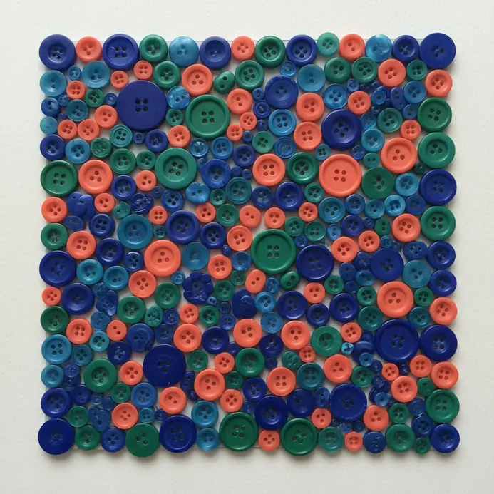 A colorful poster board is completely covered with a grid of 100 assorted buttons.