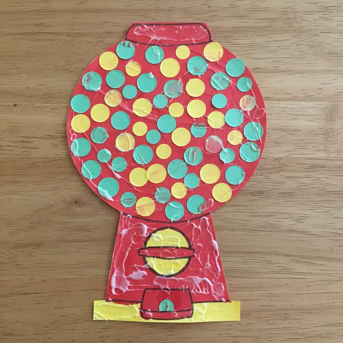 A red paper gumball machine collage is filled with 100 multicolored paper circles.