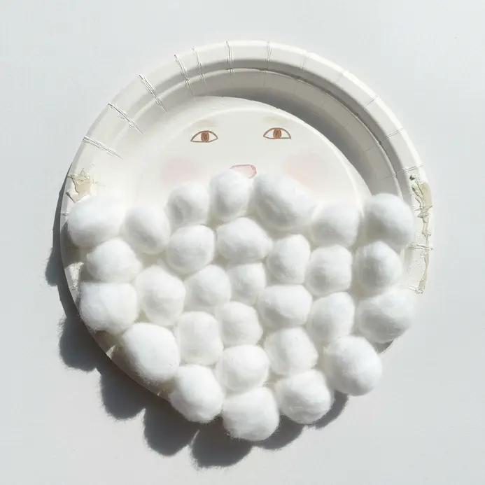 A paper plate face features a large, fluffy beard constructed from 100 cotton balls.
