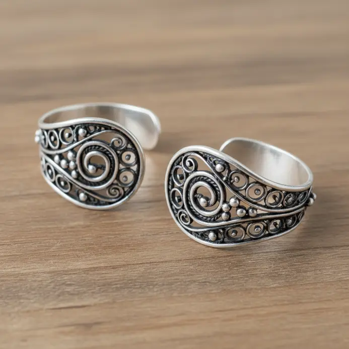 A detailed, ornate silver ear cuff with floral filigree patterns, wrapping around the ear's cartilage.