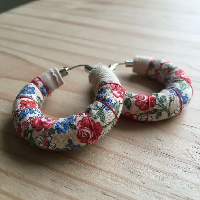 Simple metal hoop earrings completely wrapped in a tight coil of colorful, patterned cotton fabric.