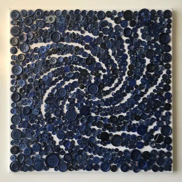 A stretched canvas covered in a gradient mosaic of navy plastic, metal, and textured buttons.