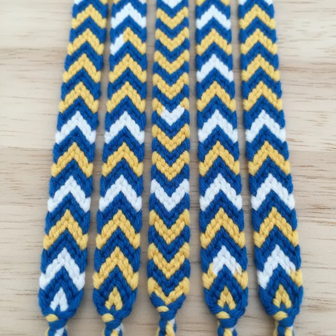 Several thin, colorful friendship bracelets woven with embroidery floss in chevron patterns.
