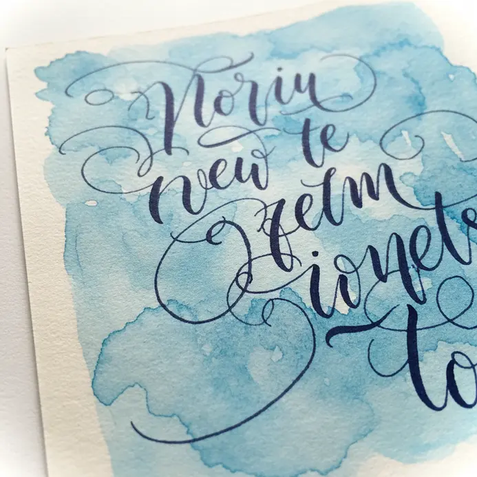 A scrapbook page with a watercolor blob background and a single, elegantly hand-lettered quote in the center.