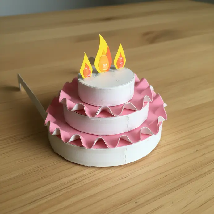 Paper glasses where the frames form a tiered birthday cake with paper candle flames on top.