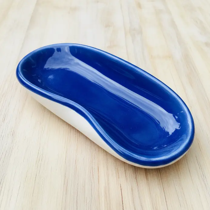 An elongated, oval-shaped pinch pot finished with a glossy blue glaze for kitchen use.