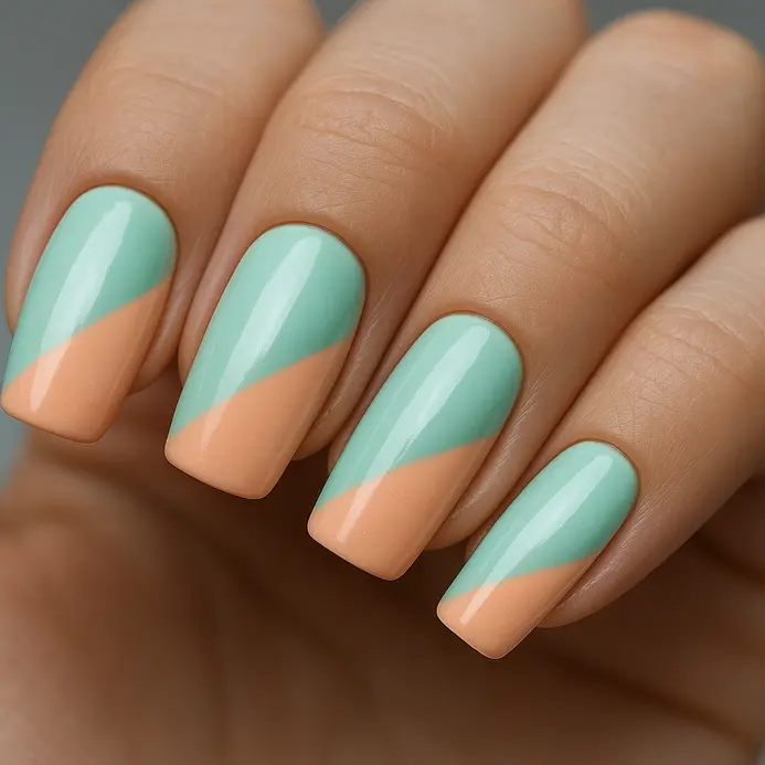 An acrylic nail split diagonally with mint green on one half and soft peach on the other.