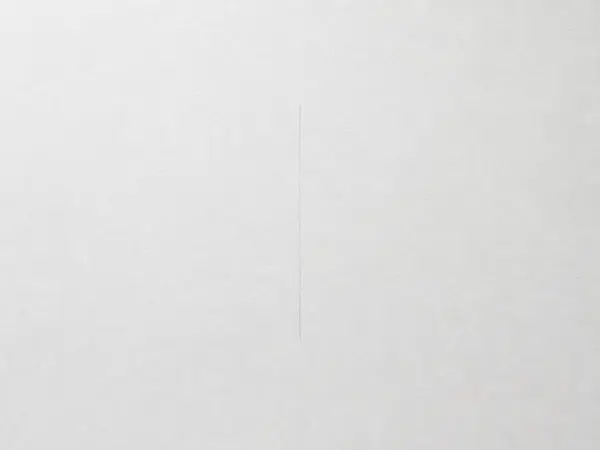 A blank white sheet of paper with a single, faint vertical pencil line drawn down the center.