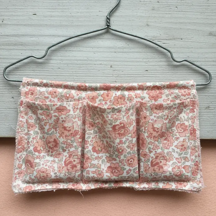 A closet organizer made by wrapping and sewing fabric around a straightened wire coat hanger to create pockets.