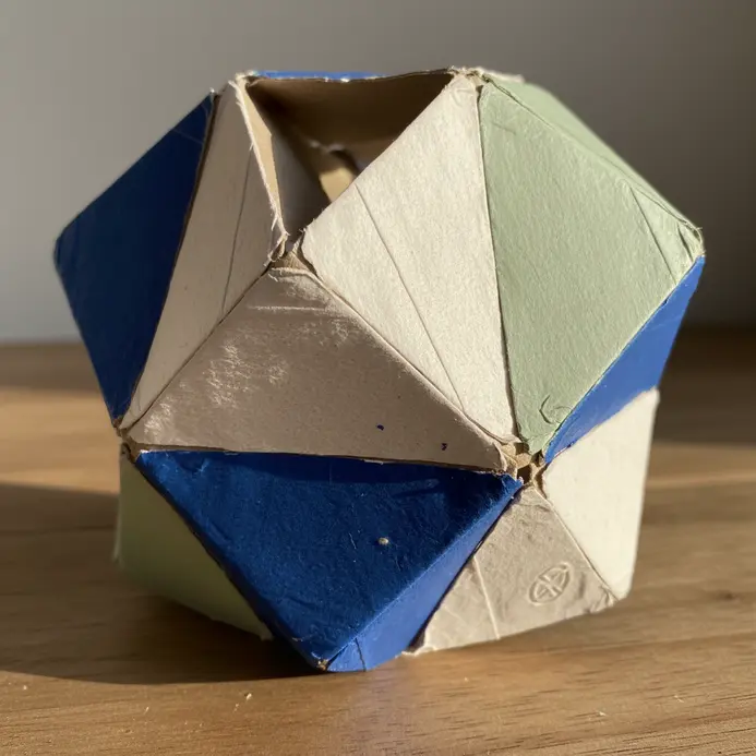 A modern, three-dimensional sculpture formed by gluing together painted cardboard tubes.